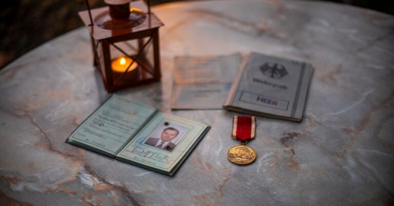 Eine Sammlung von Vintage-Militärerinnerungsstücken mit einer leuchtenden Laterne auf einem Steintisch.